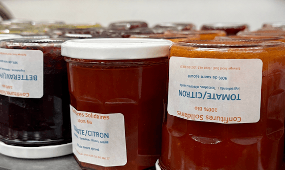 Plusieurs bocaux de confitures bio aux étiquettes blanches, saveurs tomate-citron et betterave rouge.